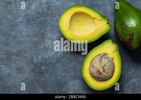 Fresh avocado is cut in half. They're high in the healthy kind of fats Stock Photo