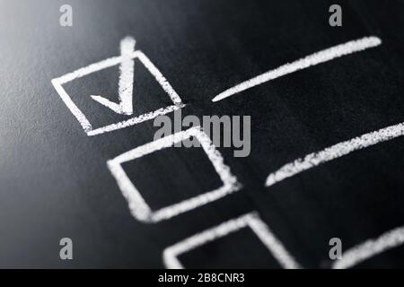 Check list on blackboard macro close up. Document of finished work duties and responsibilities. Agenda and progress in business. Stock Photo