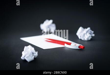 Crumpled paper, pen and empty sheet on table. Brainstorming and innovating. No or bad ideas, writer's block or trial and error concept. Stock Photo