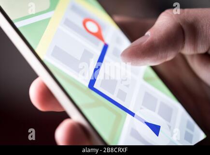 Map application in smartphone. Man navigating in city with mobile phone. Person using cellphone and searching hotel with navigation app. Stock Photo