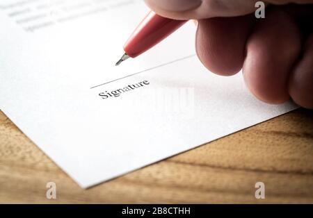 Writing signature. Man signing settlement, contract or agreement for employment and hiring, business acquisition and buyout, car lease or real estate. Stock Photo