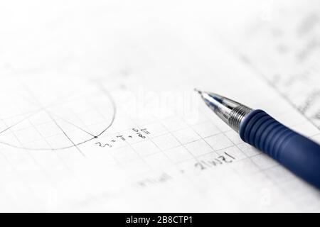 Studying mathematics and science concept. Notes in math class. Geometry, numbers, equation or formula on paper with pen. Homework, exam, assignment. Stock Photo