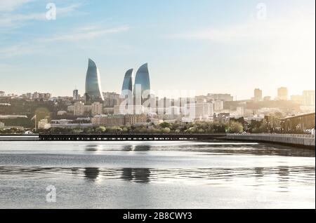 Baku city at sunset. Panoramic view of the skyline with sea boulevard, pier and Flame towers in the background. The capital city of Azerbaijan. Stock Photo