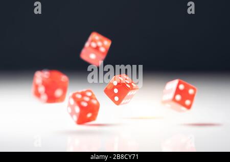 Roll the dice. Risk, luck, gambling, betting or addiction concept. Throwing five red casino and poker dice on table. Stock Photo