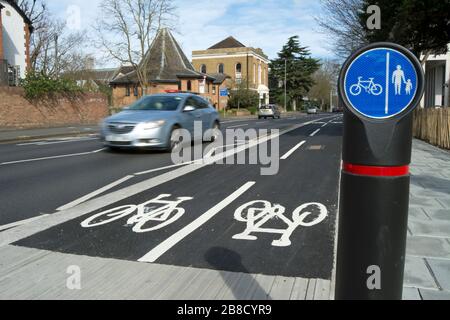 cycle track in kingston upon thames, surrey, england, with passing car seen in blurred motion and separate lanes for pedestrians and cyclists sign Stock Photo
