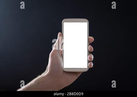 Empty mobile phone screen with dark black background in shadow at night. Hand holding smartphone with blank white display and copy space. Stock Photo