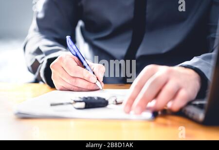 Car loan form or lease application document. Man signing paper contract to sell premium vehicle. Buyer or dealer in agency. Auto insurance. Stock Photo