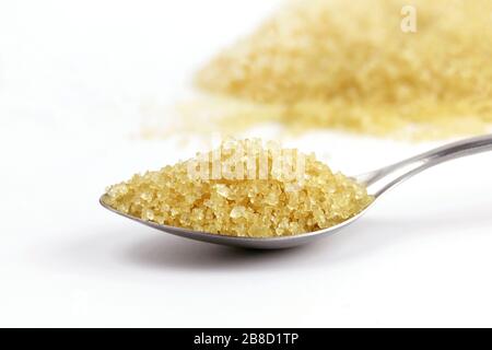 Sugar in spoon, Sugar brown heap from sugarcane on spoon stainless steel and background granulated sugar yellow Stock Photo