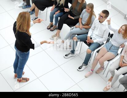 young woman standing in front of a group of diverse young people Stock Photo