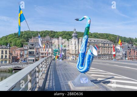 Bridge across Meuse river in Dinant, Belgium. The bridge is decorated with sculptures of saxophones, because the inventor Adolphe Sax was from Dinant. Stock Photo