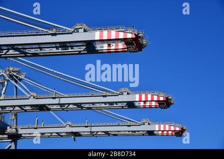 Rotterdam, The Netherlands - August 2019; low angle view of gantry cranes sticking against the sky waiting for handling ‘ship to shore’ containers