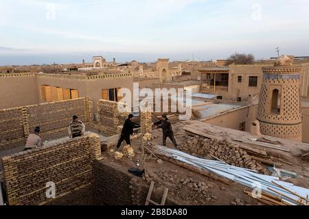 Workson the roof of a house in old town of Khiva - Uzbekistan Stock Photo