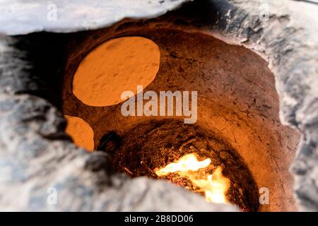 Bread baking In A Traditional Clay Oven, Khiva, Uzbekistan Stock Photo
