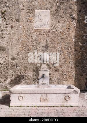 Close-up of old stone fountain at the outside of the stone curtain wall of the Grandson Castle in Switzerland. The fountain was built in 1885. Stock Photo