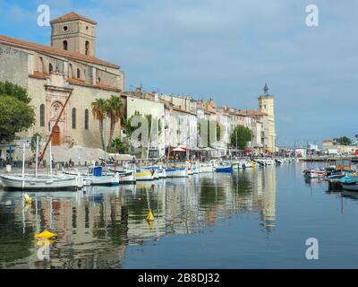 Vieux port aka old port area in a Mediterranean town of La Ciotat in Southern France with lots of docked small boats and city's main church Stock Photo