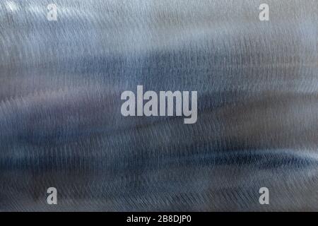 Close-up texture of flat shiny steel surface manually cleaned with a flap wheel angle grinder. Stock Photo