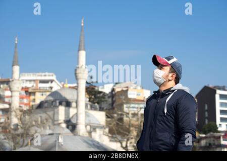 Turkish man wearing the face mask against Corona virus (covid-19) on Istanbul cityscape background. Pandemic coronavirus concept. Stock Photo
