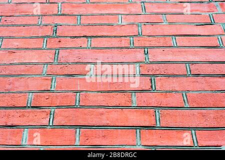 Red brick wall with large grey mortar joints. Bottom view. Background. Stock Photo