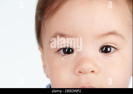 Close up of kid eye with tear isolated on white background Stock Photo