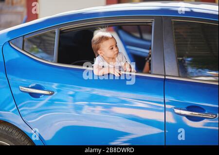 Car travel theme. Small baby girl going on car vacation Stock Photo