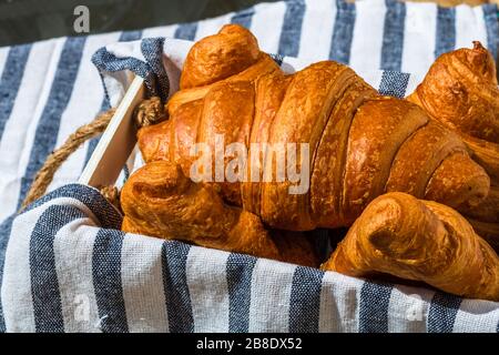 Fresh croissant, puff pastry and buttered french croissant on wooden crate. Food and breakfast concept. Detail of desserts and fresh pastries Stock Photo