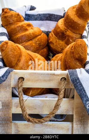 Fresh croissant, puff pastry and buttered french croissant on wooden crate. Food and breakfast concept. Detail of desserts and fresh pastries Stock Photo