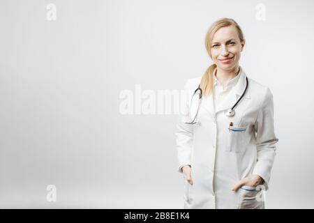 Cheerful female doctor in medical uniform posing on camera. Stock Photo
