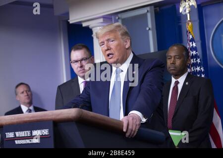Washington, United States. 21st Mar, 2020. Pete Gaynor, Administrator, Federal Emergency Management Agency (FEMA), left, and United States Secretary of Housing and Urban Development (HUD) Ben Carson, right listen as United States President Donald J. Trump makes remarks on the Coronavirus crisis in the Brady Press Briefing Room of the White House in Washington, DC on Saturday, March 21, 2020. Photo by Stefani Reynolds/UPI Credit: UPI/Alamy Live News Stock Photo