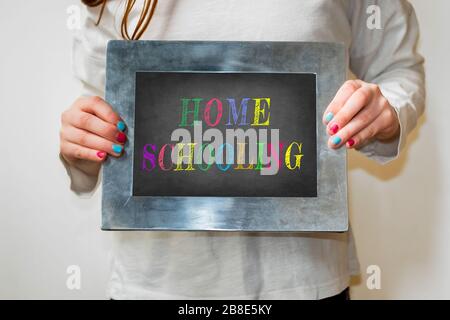child holding up a blackboard with the word homeschooling Stock Photo