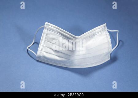 Protective face mask on blue background Stock Photo