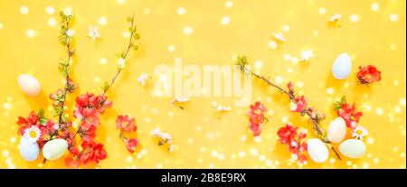 Easter eggs and flowers on yellow  background Stock Photo