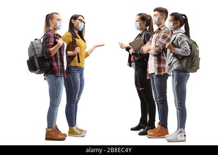Young casual people standing in a group, talking and wearing protective medical masks isolated on white background Stock Photo