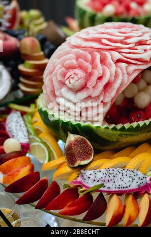 Different fruits on festive tables with grapes, berries, pitahaya, watermelon. Tropical fruits assortment and celebration or another event. Stock Photo