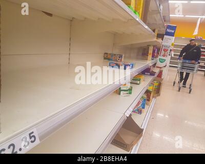 London, UK - 17 March 2020: A shopper walk past empty shelves in a supermarket in East London following panic buying with the anticipated Covid-19 lock down. Photos: David Mbiyu/ Alamy Live News Stock Photo