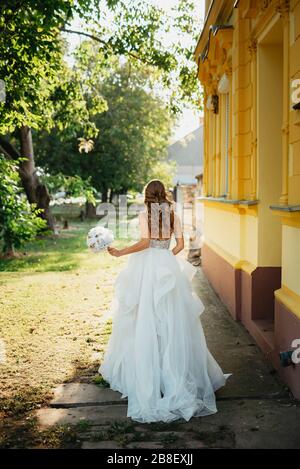 The bride in a beautiful wedding dress with a bouquet in her hand