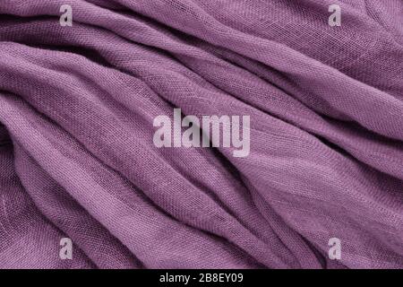 Purple draped linen fabric or scarf background. Stock Photo