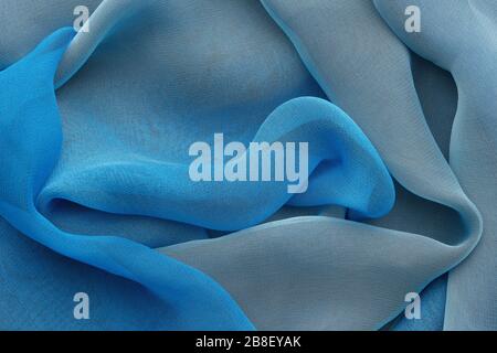 Blue draped silk fabric or scarf. Silk waves background. Stock Photo