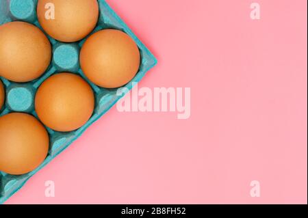 Raw brown chicken eggs on pink background . Stock Photo