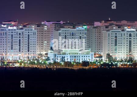 Ashgabat, Turkmenistan skyline illuminated at night. Famous as the White Marble City due to its multiple residential buildings of marble. Stock Photo