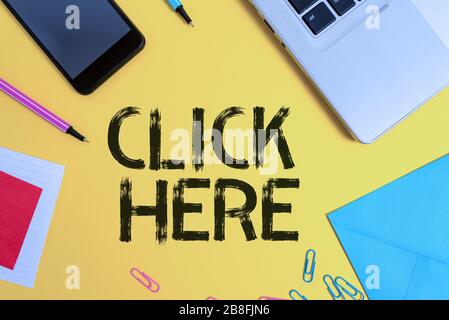 Conceptual hand writing showing Click Here. Concept meaning carry out a computer operation by pressing a button on the mouse Laptop smartphone notepad Stock Photo