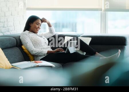 Portrait Of Businesswoman Doing Remote Work On Sofa Stock Photo