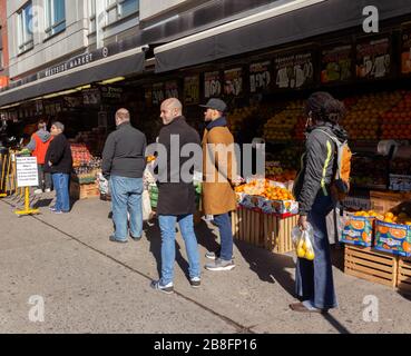 customers at the Westside Market had to wait in line on the sidewalk six feet apart to get into the store due to the coronavirus pandemic Stock Photo