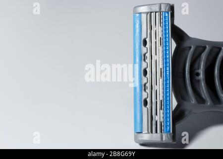 Shaving blade close-up with blue and gray colors. . The razor is on the right and only the head is photographed. Stock Photo