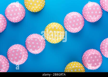 Muffin cases. Cake cases. Top View. Flat laying. Blue background.  Flat View. Straight line from corner to corner. Cupcake case. paper colorful cupcak Stock Photo