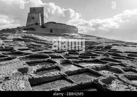 Salt Pans and Xlendi Tower on Ras il-Bajda, Gozo, Malta Stock Photo