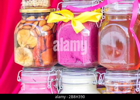 Glass jars with different sorts of honey on red background Stock Photo