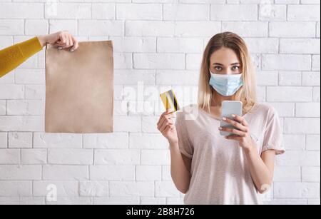 Online shopping during coronavirus quarantine. Female in protective mask Stock Photo