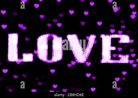 blurred text purple LOVE sign LED Bokeh neon light purple on background bokeh lights heart soft colorful Stock Photo