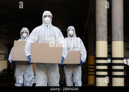 People in protective suits and masks delivering vaccine Stock Photo