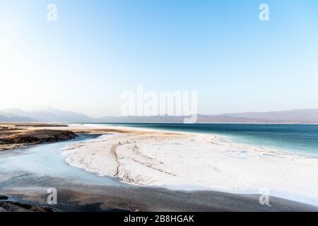 Africa, Djibouti, Lake Assal. Landscape view of lake Assal with mountains in the background. and people harvesting salt Stock Photo